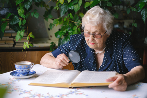 mature woman needing magnifying glass to read